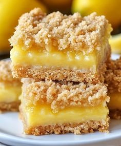 three pieces of cake sitting on top of a white plate next to some lemons