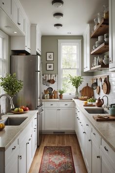 a kitchen filled with lots of white cabinets and counter top space next to a window