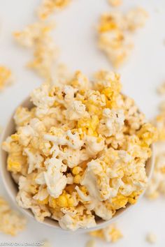 a white bowl filled with popcorn on top of a table