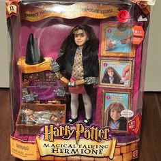 the doll is in its box with harry potter memorabilia on it's display stand