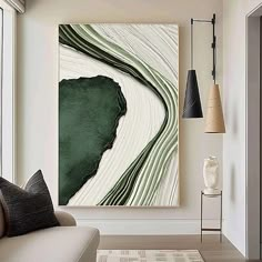 an abstract painting hangs on the wall above a couch in front of a large window