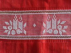 an embroidered red cloth with white letters on it