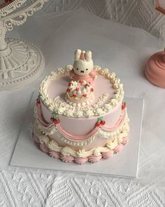 there is a cake that has been decorated with an animal on the top and pink frosting