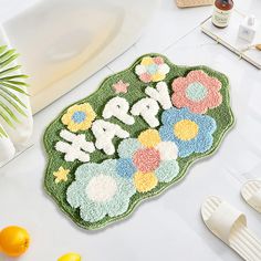 a bath mat with flowers and the word mom on it