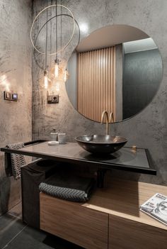 a bathroom with a round mirror above the sink