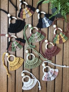 small crocheted tassels are laid out on a wooden table next to a potted plant