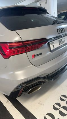 the rear end of a silver car parked in a garage