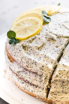 a cake with lemons and poppy seeds on it sitting on a white platter