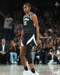 a female basketball player walking on the court with her foot in the air and people watching