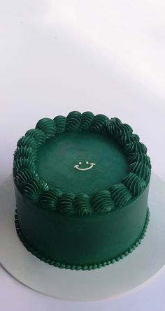 a green cake sitting on top of a white plate