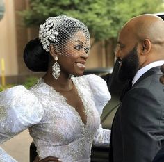 a man in a suit and tie standing next to a woman in a wedding dress