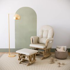 a chair and ottoman in a room with an arch on the wall behind it, next to a floor lamp