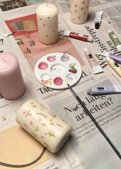 the table is covered with candles and other crafting supplies