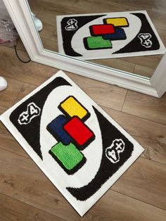 two bathroom rugs on the floor in front of a mirror with an abstract design