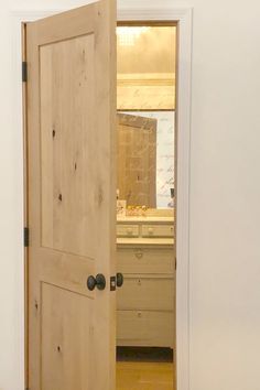 an open wooden door in a white room