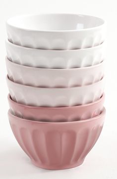 a stack of pink and white bowls sitting on top of each other