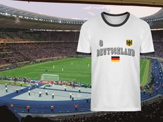 a t - shirt with the word germany on it is in front of a stadium