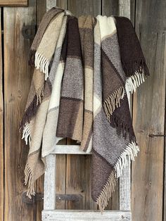 a chair with a blanket on top of it next to a wooden wall and door