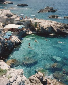 people are swimming in the clear blue water