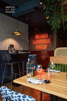 a restaurant with wooden tables and chairs, neon signs on the wall behind them that read bushish lowers only