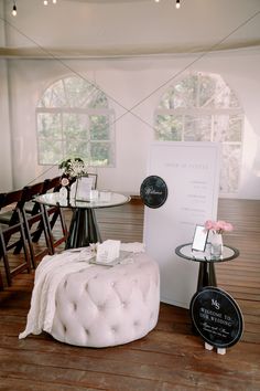 a room with chairs, tables and a sign on the floor in front of it