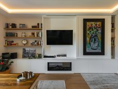 a living room filled with furniture and a flat screen tv mounted on the wall above a fireplace