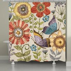 a shower curtain with colorful flowers and butterflies on the outside, in front of a bathtub