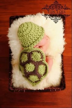 a newborn baby is wearing a turtle hat