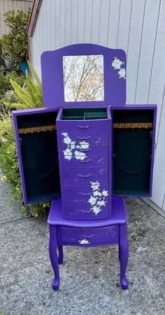 a purple vanity with drawers and mirror on the top is sitting in front of a house