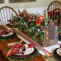 the table is set for christmas dinner with plaid napkins and place settings on it