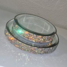 two glass plates with colorful lights on them sitting on a table top next to each other