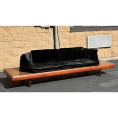 a black couch sitting on top of a wooden table