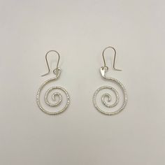 Sterling silver swirl dangle earrings with French hook wires, a unique and elegant design. Handmade by Zuni artist, Carlton Jamon. Measurements: 2" x 0.9" (including wire) Weight: 0.19oz (5.4g) Material: sterling silver (silver925) Sterling Silver Swirl Jewelry, Sterling Silver Swirl Jewelry In Silver, Handmade Spiral Sterling Silver Wrap Earrings, Silver Spiral Wrap Earrings In Sterling Silver, Modern Twist Silver Spiral Earrings, Elegant Spiral Sterling Silver Wrap Earrings, Nickel Free Silver Swirl Earrings, Handmade Silver Swirl Earrings, Swirl Shaped Sterling Silver Earrings For Gifts