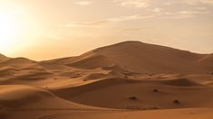 the sun is setting over some sand dunes