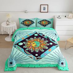 a bed covered in a blue and green comforter next to a white nightstand with a clock on it