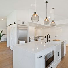 a kitchen with an island and three pendant lights