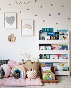 a child's room with bookshelves, toys and pictures on the wall