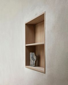 an empty wooden shelf with a rock in it