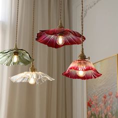 three flower shaped lights hanging from a ceiling