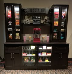 a display case filled with lots of food and drinks next to a wall mounted movie projector