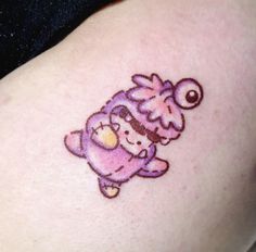 a small cartoon character tattoo on the back of a woman's thigh