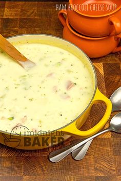 a yellow pot filled with soup next to two spoons