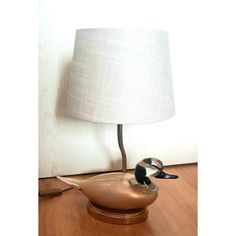 a lamp that is sitting on top of a wooden floor next to a duck shaped object