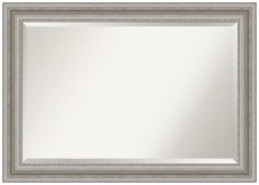 a white and silver framed mirror on a white wall with an ornate border around the edges