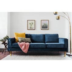 a living room with a blue couch and two pictures on the wall