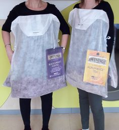 two women standing next to each other wearing aprons