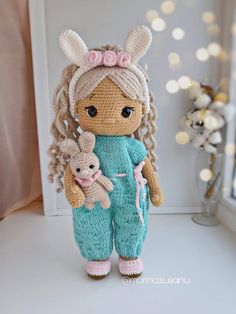 a crocheted doll holding a stuffed animal