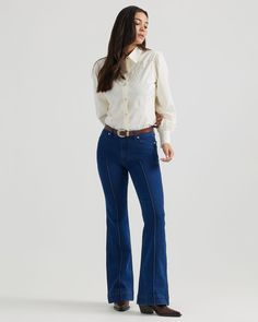 Saddle up to a vintage fit with the Wrangler® x Yellow Rose by Kendra Scott High Rise Trouser in Rinsed Wrangler Blue. These flared jeans come fully accented with piped stitching along the front seam, turquoise buttons in our signature Davie frame with matte gold trim, scalloped yokes on the back pockets, and a sleek silhouette that flatters from every angle. Best of all, they’re crafted from a classic twill fabric for long-lasting quality. Pair it with the ‘70s Fitted Blazer to complete the loo Urban Cowgirl, Vintage Fits, Trending Boots, Cowboy Style, Fitted Blazer, Kendra Scott, Family Outfits, Quality T Shirts, Yellow Roses