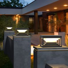 three lights that are on top of some concrete blocks in front of a house at night