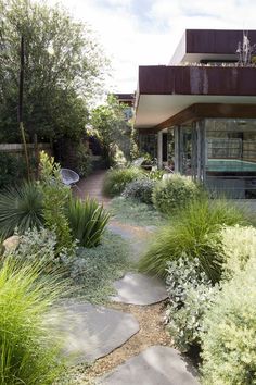 a house with lots of plants in front of it